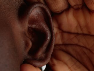 Hand cupped around an ear